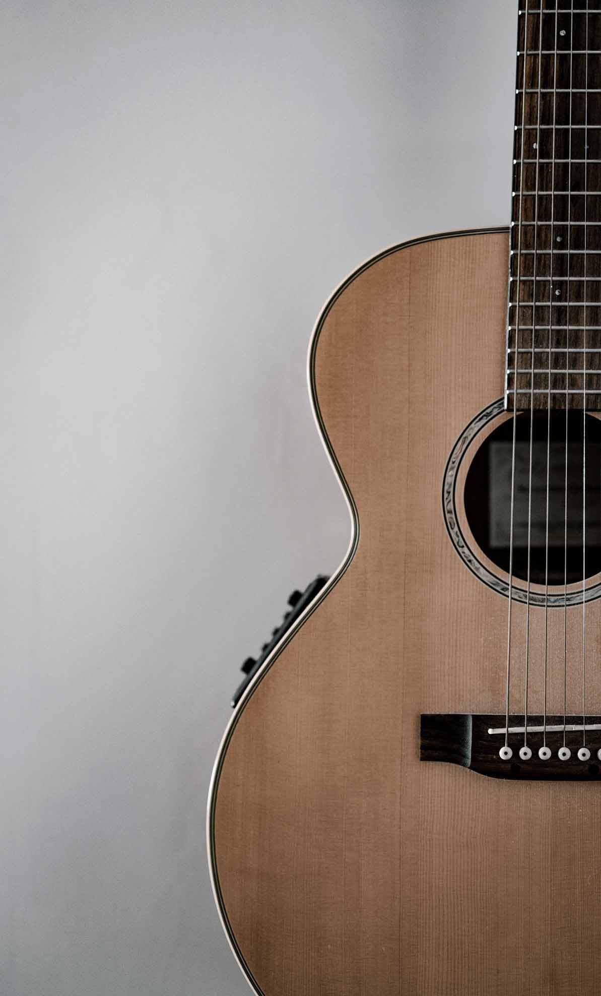 guitar standing against gray wall